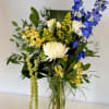 A modern arrangement with tall blue delphinium and hanging amaranthus