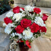 A beautiful arrangement of white and red carnations with red roses designed