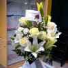 A classic and peaceful arrangement featuring white lilies, creamy white roses, delicate