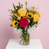 A mix of sunflowers, yellow roses, and hot pink blooms in a