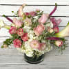 Hydrangeas, Roses and other various flowers and greens are arranged in a