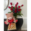Bouquet of red roses with a teddy bear and chocolate box