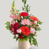 A cozy arrangement filled with long lasting carnations, a snapdragon, hypericum berries