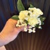 A neatly styled boutonniere created to coordinate beautifully with the bridal bouquet