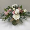 This arrangement contains Carnations, Spray Roses and soft muted Roses against the