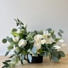 Beautiful one-sided arrangement with a mixture of roses, orchids, greenery, and more.