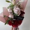 A romantic blend of blush roses, soft pink lilies, and bold red