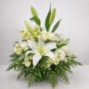 Graceful and calming, Serenity Blooms features white lilies, roses, and seasonal blooms