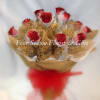 A Dozen Red glittered roses arranged in gold wrapping paper and white