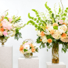 A soft yet striking collection of tall, airy floral arrangements in peach