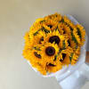 Bouquet of bright yellow sunflowers wrapped in white paper
