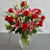 Clear vase w/ stargazer lilies, a dozen red roses and filler. 