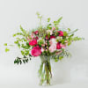 In this exquisite pink flower arrangement, delicate petals unfurl in a symphony