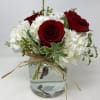 Floral arrangement consisting of red roses, hydrangeas and foliage. 

*NOTE: Roses can
