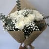 One dozen white roses arranged into a hand-tied bouquet with fillers and