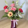 Pink roses with white lilies in a pink vase