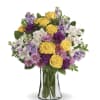 Yellow roses, white alstroemeria, pompons, chrysanthemum, greenery in a clear glass gathering