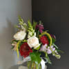 This beautiful flower arrangement of fresh mixed seasonal blooms is made by
