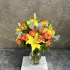 Alstroemeria, lilies and roses in bright happy yellows and orange with eucalyptus.