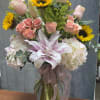 Blushing sun is a vibrant and elegant arrangement featuring radiant sunflowers 