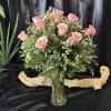 1 dozen light pink roses in a glass vase