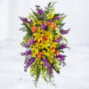 Tall bouquet of yellow lilies, orange roses, and purple flowers