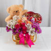 A heartwarming gift basket filled with pink daisies, alstroemerias, and orange roses