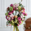 Classic memorial wreath in warm shades of pinks, greens and white, accented