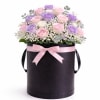 An elegant floral arrangement featuring 24 roses in soft blush, lavender, and