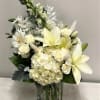 Mixture of white flowers such as lilies, spray roses, alstromeria, hydrangeas, snapdragon