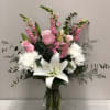 White and pink assortment of flowers such as lilies, mums, roses, snaps