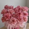 A romantic arrangement of blush pink roses in a chic round box