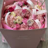 Pink bouquet in a box with roses and hydrangeas tied with white ribbons