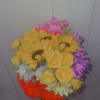 Handheld bouquet of yellow, pink, purple, white, and orange flowers