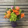 Purple frosted diamond vase filled with vivid orange, green and pop of