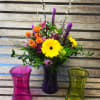 Colored glass gathering vase ( colors vary) filled with vivid spring flowers.