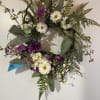 A permanent wreath with white and plum colored faux blooms