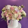 This charming arrangement features soft pink and ivory roses, delicate orchids, and