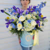 This vibrant flower arrangement combines cheerful Daisies, elegant Irises, romantic Roses, charming