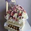 Heart-shaped box of pink and white roses with chocolates in a drawer and a purple butterfly decoration.