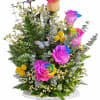 Rainbow-tinted roses in a white vase with a butterfly decoration