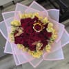 Bouquet of red roses with yellow flowers wrapped in pink paper