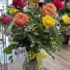 One dozen assorted color roses beautifully arranged in a glass vase