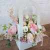 Designed in a flower box, this arrangement overflows with soft shades of
