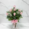 Pink roses in a glass vase with a pink ribbon bow