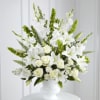 White floral arrangement in a white vase with green accents