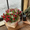 A vibrant basket of fresh red tulips accented with delicate white florals