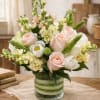 A seasonal arrangement of colors featuring roses, tulips, stock and other spring