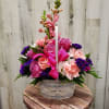 This White basket with Pink and Purple flowers is great for any