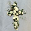 A serene and elegant standing cross featuring pristine white roses and delicate
